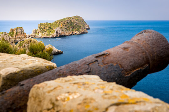 Panoramic view from viewpoint of the Malgrat Islands cannon in Santa Ponsa above the mediterranean sea with islands Illes Malgrats in the background and a blurred old rusty cannon in the foreground.