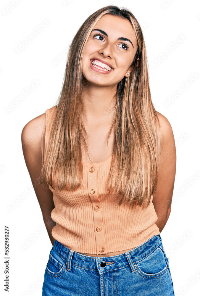 Sticker Hispanic young woman wearing casual summer shirt looking away to side with smile on face, natural expression. laughing confident.