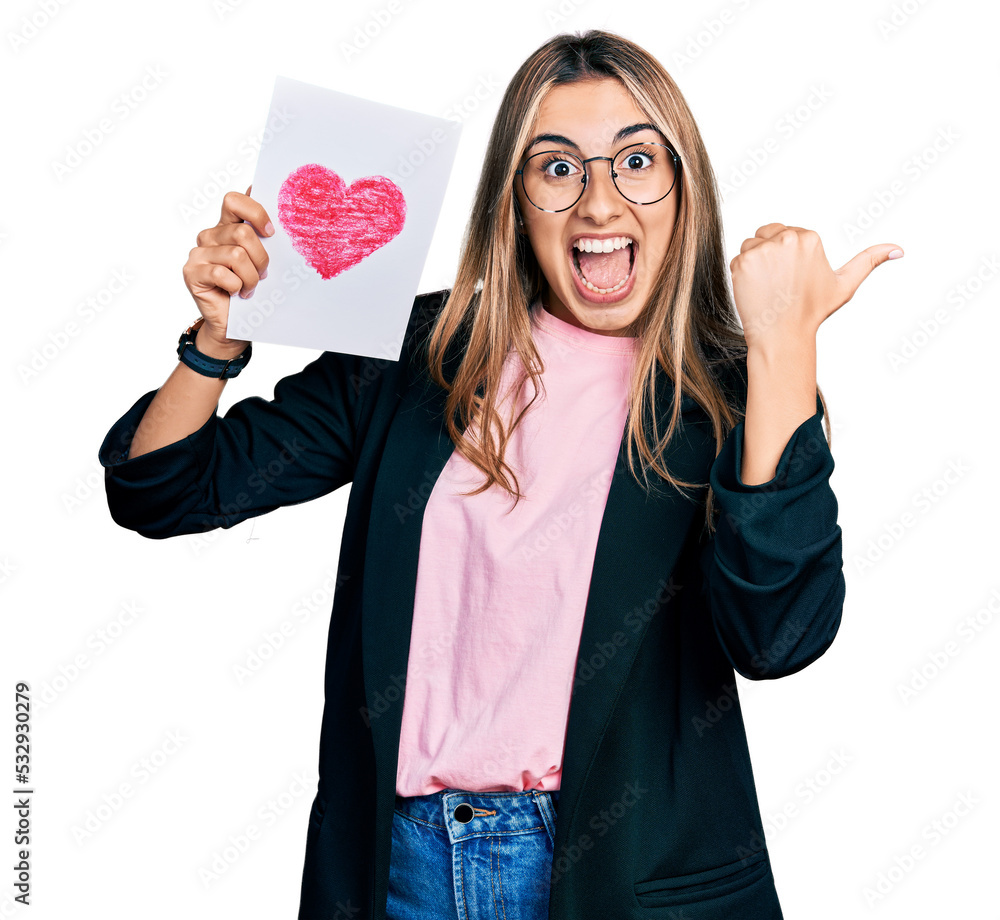 Poster hispanic young woman holding heart draw pointing thumb up to the side smiling happy with open mouth