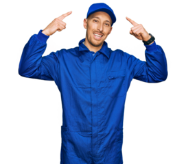 Bald man with beard wearing builder jumpsuit uniform smiling pointing to head with both hands finger, great idea or thought, good memory