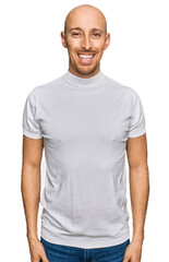 Obraz premium Bald man with beard wearing casual white t shirt with a happy and cool smile on face. lucky person.