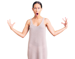 Beautiful brunette young woman wearing casual dress crazy and mad shouting and yelling with aggressive expression and arms raised. frustration concept.