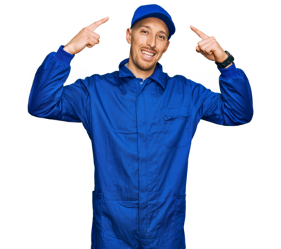 Bald man with beard wearing builder jumpsuit uniform smiling pointing to head with both hands finger, great idea or thought, good memory