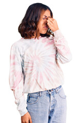 Young beautiful mixed race woman wearing casual tie dye sweatshirt tired rubbing nose and eyes feeling fatigue and headache. stress and frustration concept.