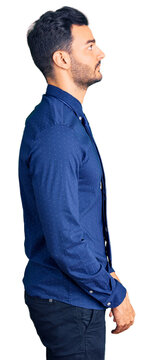 Young handsome hispanic man wearing business clothes looking to side, relax profile pose with natural face with confident smile.