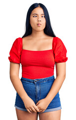 Fototapeta premium Young beautiful asian girl wearing casual clothes making fish face with lips, crazy and comical gesture. funny expression.