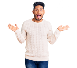 Handsome latin american young man wearing casual winter sweater celebrating victory with happy smile and winner expression with raised hands