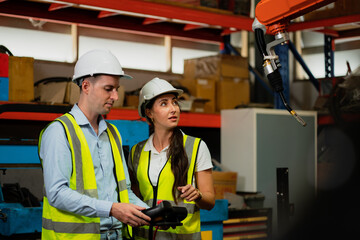 Engineer worker is controlling a welding robot, Male technician worker working with control automatic robot arm system welding in the factory.