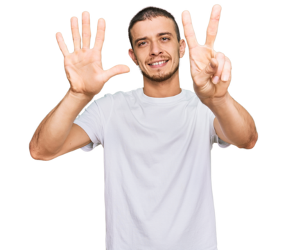 Hispanic young man wearing casual white t shirt showing and pointing up with fingers number seven while smiling confident and happy.
