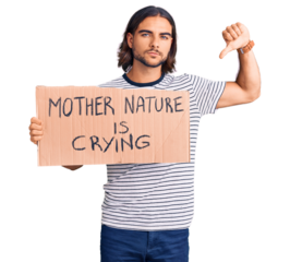 Young handsome man holding mother nature is crying protest cardboard banner with angry face, negative sign showing dislike with thumbs down, rejection concept