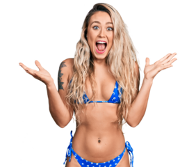 Young blonde woman wearing bikini celebrating crazy and amazed for success with arms raised and open eyes screaming excited. winner concept