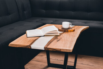Epoxy wooden table. A cup of coffee and a book on the table. Morning and breakfast