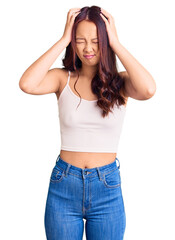 Fototapeta premium Young beautiful chinese girl wearing casual clothes suffering from headache desperate and stressed because pain and migraine. hands on head.