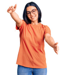 Young beautiful latin woman wearing casual clothes looking at the camera smiling with open arms for hug. cheerful expression embracing happiness.