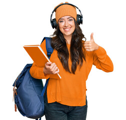 Beautiful brunette young woman wearing student backpack and holding books smiling happy and...
