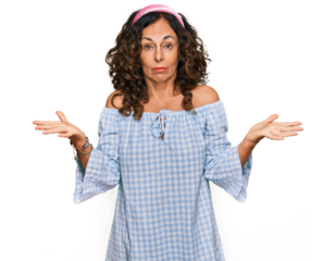 Middle age hispanic woman wearing casual clothes clueless and confused expression with arms and hands raised. doubt concept.