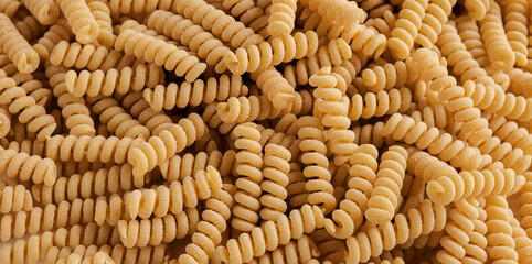 Gluten Free Cornmeal Pasta Wallpaper. Spiral Raw Macaroni from Corn and Rice flour rotating on...