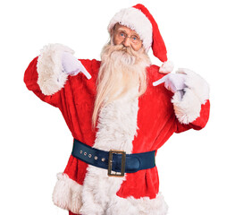 Old senior man with grey hair and long beard wearing traditional santa claus costume looking...