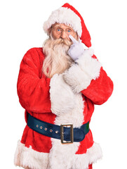 Old senior man with grey hair and long beard wearing traditional santa claus costume pointing to the eye watching you gesture, suspicious expression