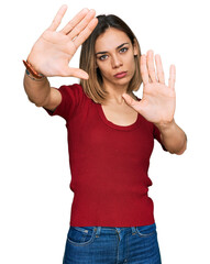 Young blonde girl wearing casual clothes doing frame using hands palms and fingers, camera perspective