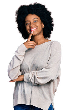 Young African American Woman Wearing Casual Clothes Looking Confident At The Camera With Smile With Crossed Arms And Hand Raised On Chin. Thinking Positive.