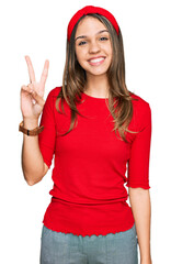 Obraz na płótnie Canvas Young brunette woman wearing casual clothes showing and pointing up with fingers number two while smiling confident and happy.