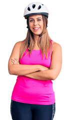 Young beautiful woman wearing bike helmet happy face smiling with crossed arms looking at the camera. positive person.