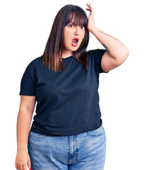Fototapeta premium Young plus size woman wearing casual clothes surprised with hand on head for mistake, remember error. forgot, bad memory concept.