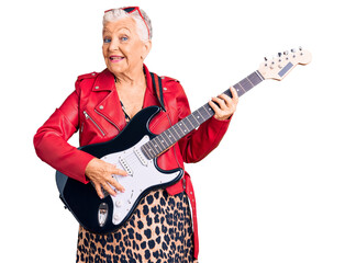Senior beautiful woman with blue eyes and grey hair wearing a modern look playing electric guitar...