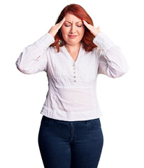 Fototapeta premium Young beautiful redhead woman wearing casual shirt suffering from headache desperate and stressed because pain and migraine. hands on head.