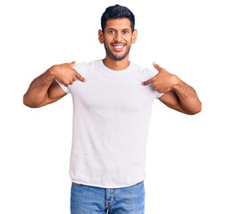 Young latin man wearing casual clothes looking confident with smile on face, pointing oneself with fingers proud and happy.