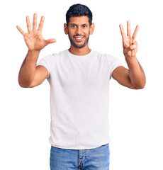 Young latin man wearing casual clothes showing and pointing up with fingers number eight while smiling confident and happy.