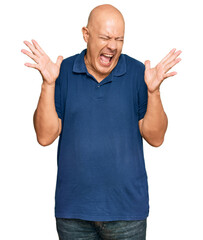 Fototapeta premium Middle age bald man wearing casual clothes celebrating mad and crazy for success with arms raised and closed eyes screaming excited. winner concept