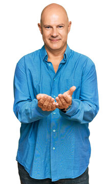 Middle age bald man wearing casual clothes smiling with hands palms together receiving or giving gesture. hold and protection