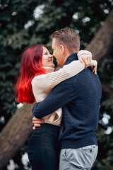 Loving couple of young people having fun on nature, young girl with red hair