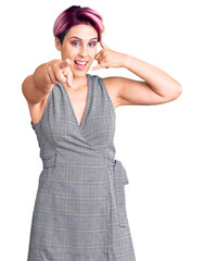 Young beautiful woman with pink hair wearing casual clothes smiling doing talking on the telephone...