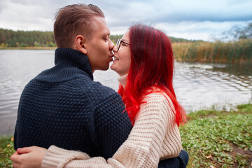 Loving couple of young people having fun on nature, young girl with red hair