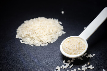 Pile of rice in a spoon with black background