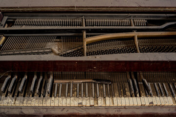Fototapeta na wymiar Close up urbex background of wood classical acoustic grand piano keyboard with sepia toned white and black keys full of dust. Creative full screen composed macro photography in dark place.