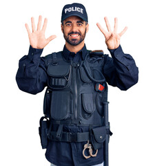 Young hispanic man wearing police uniform showing and pointing up with fingers number nine while smiling confident and happy.