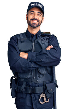 Young hispanic man wearing police uniform happy face smiling with crossed arms looking at the camera. positive person.