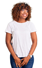 Young african american woman wearing casual white tshirt looking away to side with smile on face, natural expression. laughing confident.