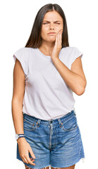 Obraz premium Young caucasian woman wearing casual white tshirt touching mouth with hand with painful expression because of toothache or dental illness on teeth. dentist