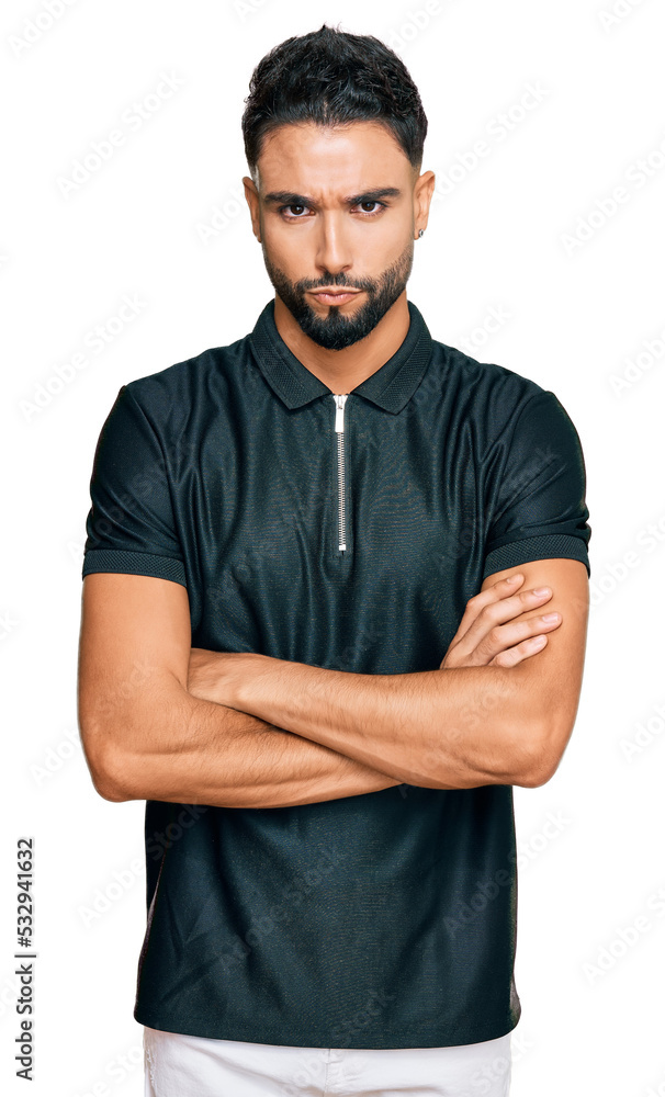 Wall mural Young man with beard wearing sportswear skeptic and nervous, disapproving expression on face with crossed arms. negative person.