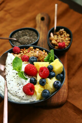 Healthy breakfast bowl with chia yogurt, crunches and fruits.