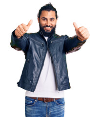 Young arab man wearing casual leather jacket approving doing positive gesture with hand, thumbs up smiling and happy for success. winner gesture.