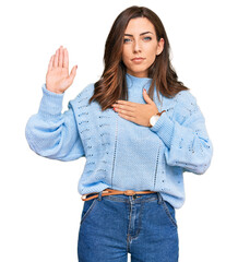Young brunette woman wearing casual winter sweater swearing with hand on chest and open palm,...