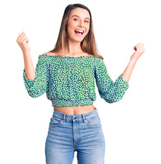 Young beautiful girl wearing casual t shirt screaming proud, celebrating victory and success very...