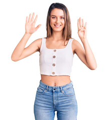 Obraz na płótnie Canvas Young beautiful girl wearing casual sleeveless t shirt showing and pointing up with fingers number nine while smiling confident and happy.