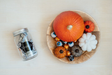 Save Money Halloween, Savings, Halloween on Budget. Glass mason jar piggy bank with dollars cash on Halloween pumpkin decoration background